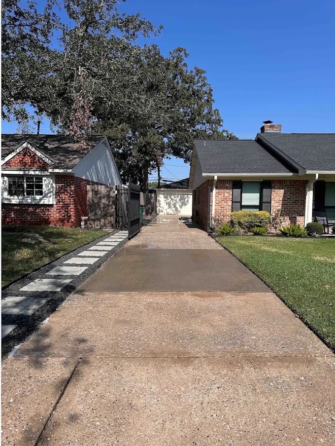 Freshly pressure washed concrete driveway at a Houston home, clean and even